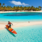 **Prompt:** Cape Verde, Sal Island, white sand beach, turquoise sea, colorful fish, snorkelers, windsurfers, palm trees, clear blue sky, sunny, vibrant colors, tropical paradise.